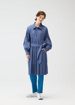 A model wears the PLEATS PLEASE ISSEY MIYAKE SMOOTH COAT coat.