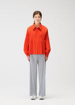A model wears the PLEATS PLEASE ISSEY MIYAKE SMOOTH COAT coat.