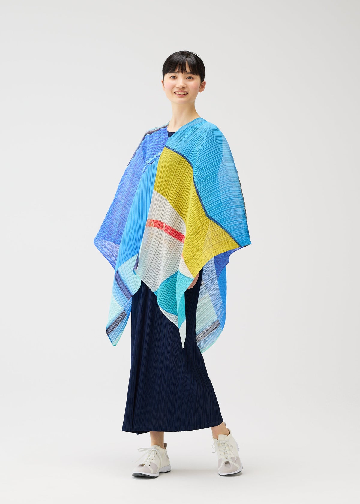 A model wears the PLEATS PLEASE ISSEY MIYAKE CITY COLLAGE MADAME T accessories.