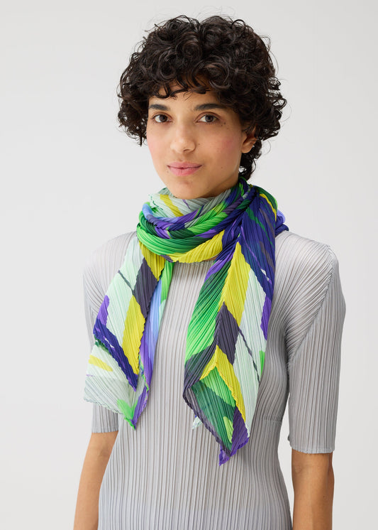 A model wears the PLEATS PLEASE ISSEY MIYAKE PLAYGROUND SCARF stole.