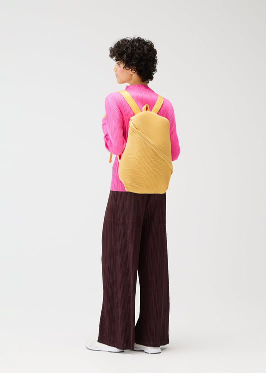 A model wears the PLEATS PLEASE ISSEY MIYAKE BIAS PLEATS BACKPACK bags.