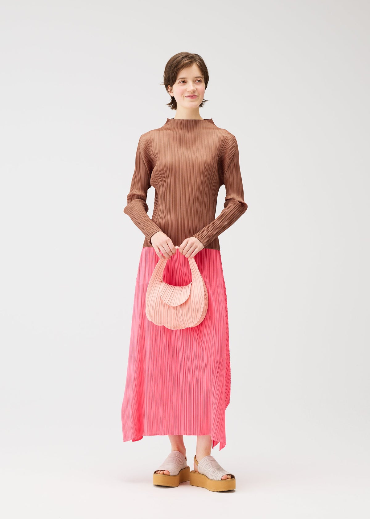 A model wears the PLEATS PLEASE ISSEY MIYAKE PLEATS SEEDS BAG bag.
