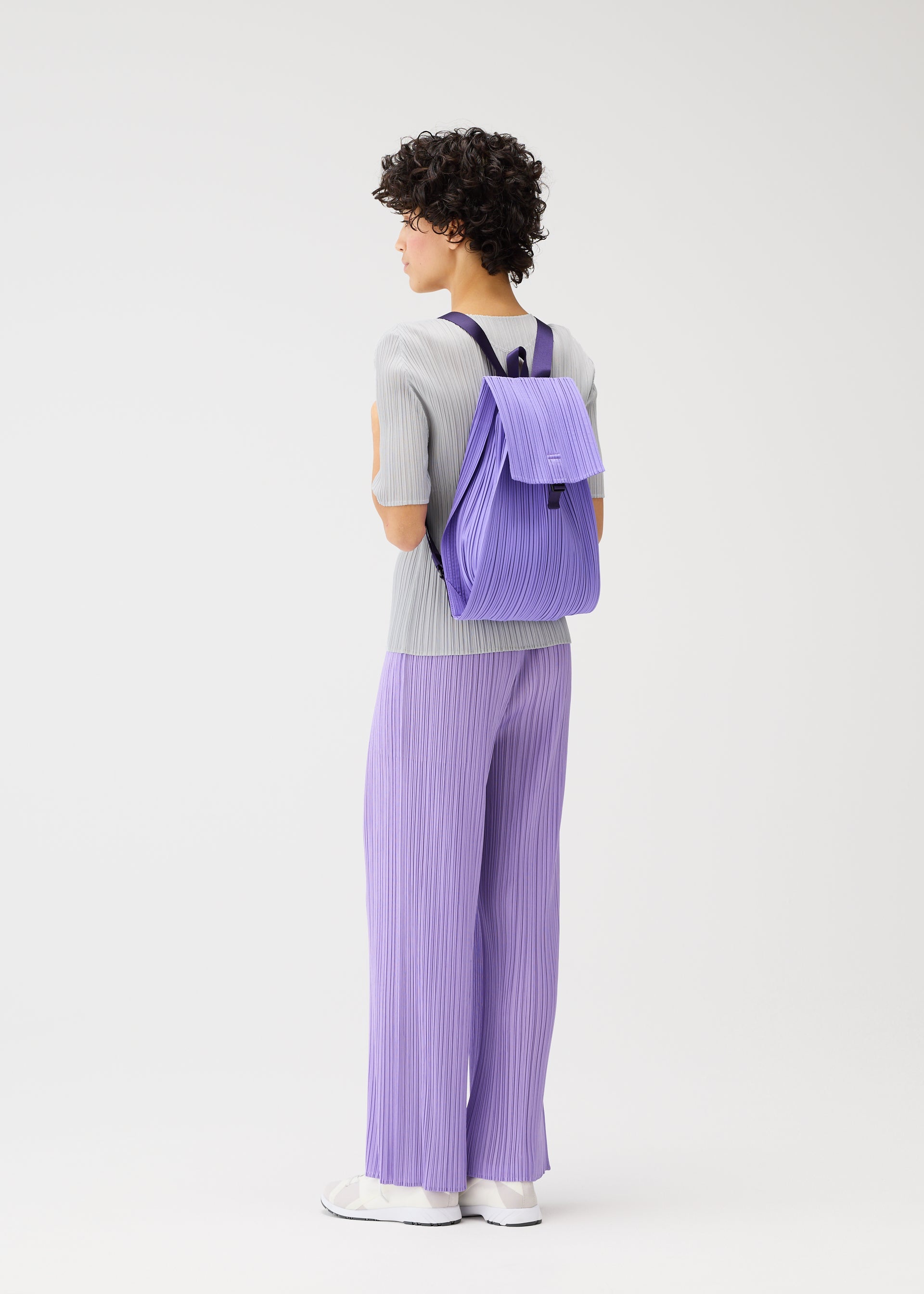 A model wears the PLEATS PLEASE ISSEY MIYAKE PLEATS KNAPSACK bag.