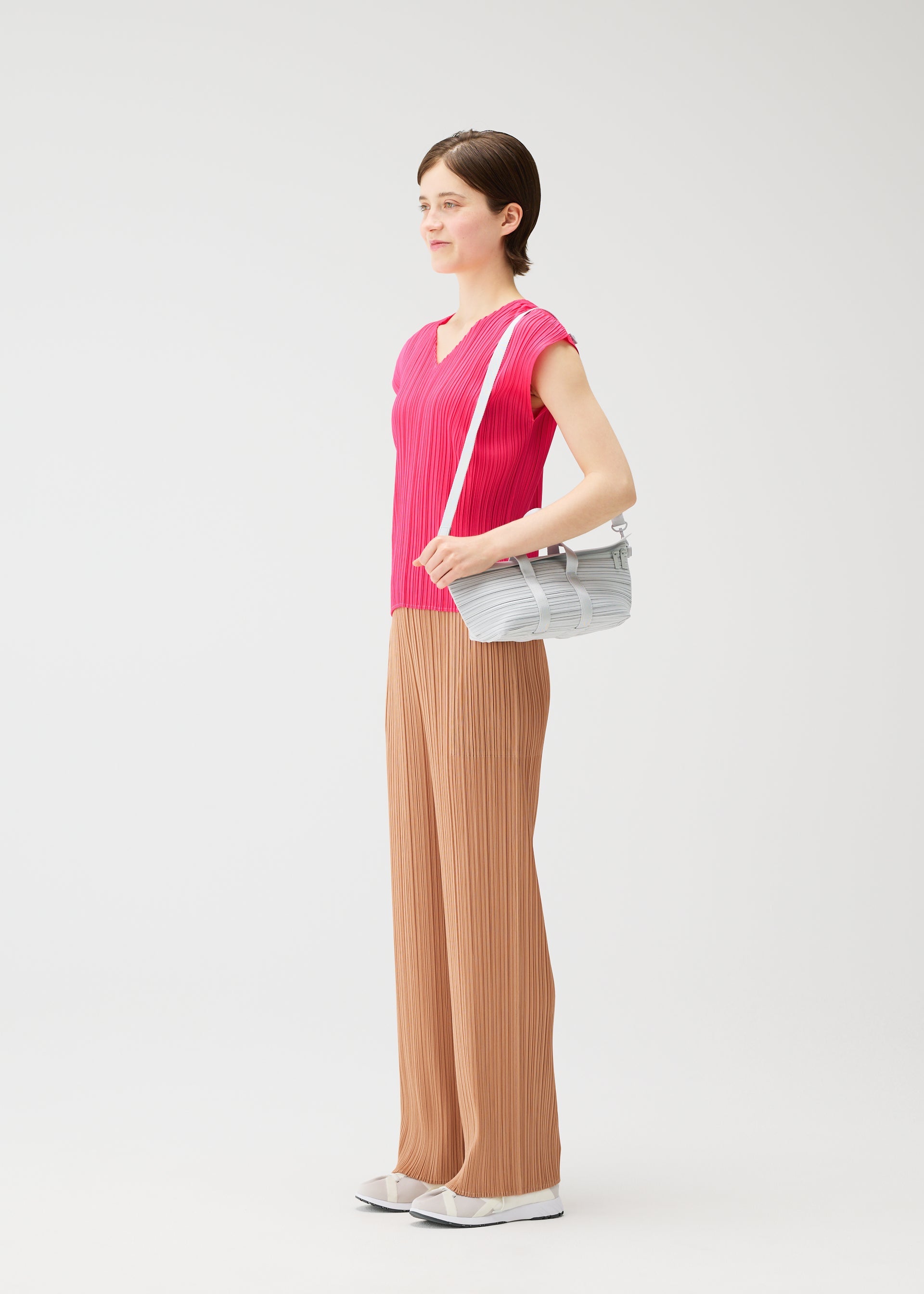 A model wears the PLEATS PLEASE ISSEY MIYAKE PLEATS BOSTON BAG pleats-boston-bag-bag-yellow-green.