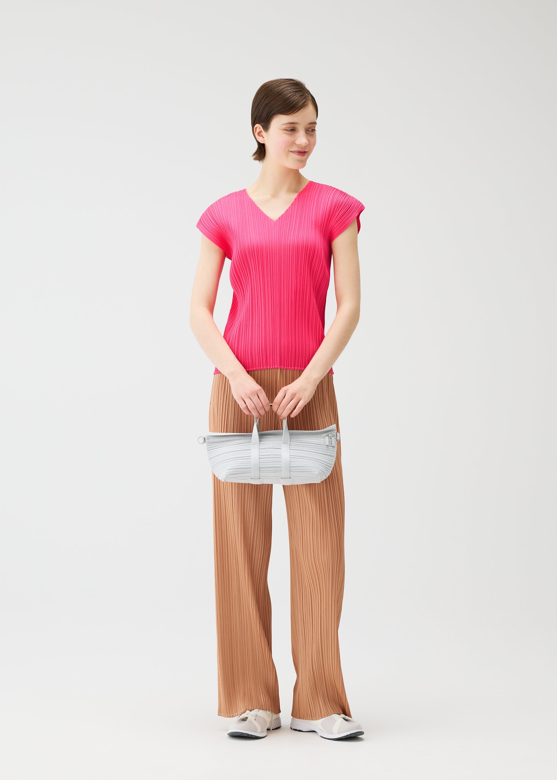 A model wears the PLEATS PLEASE ISSEY MIYAKE PLEATS BOSTON BAG pleats-boston-bag-bag-yellow-green.