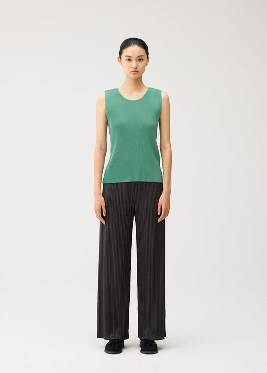 A model wears the PLEATS PLEASE ISSEY MIYAKE MIST AUGUST mist-august-top-greyish-green.