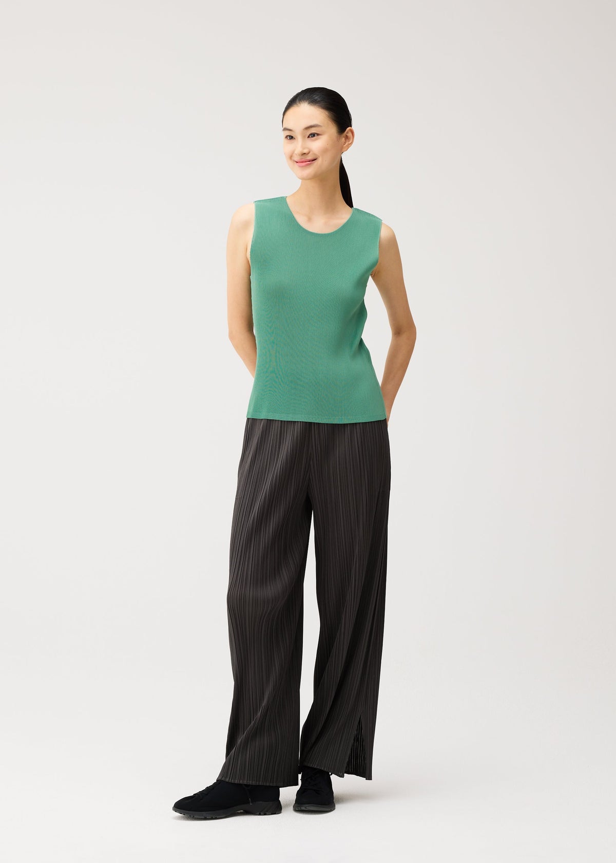 A model wears the PLEATS PLEASE ISSEY MIYAKE MIST AUGUST mist-august-top-greyish-green.