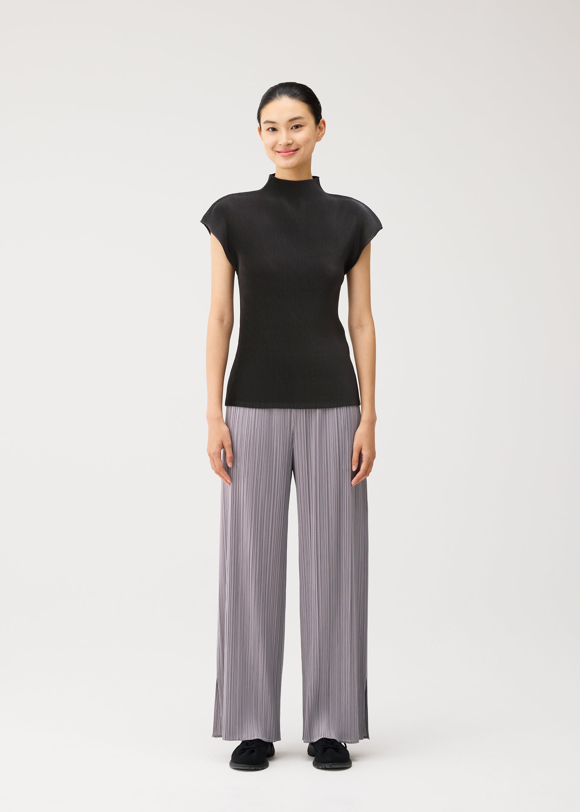 A model wears the PLEATS PLEASE ISSEY MIYAKE MIST AUGUST mist-august-cap-sleeved-high-neck-top-greyish-green.