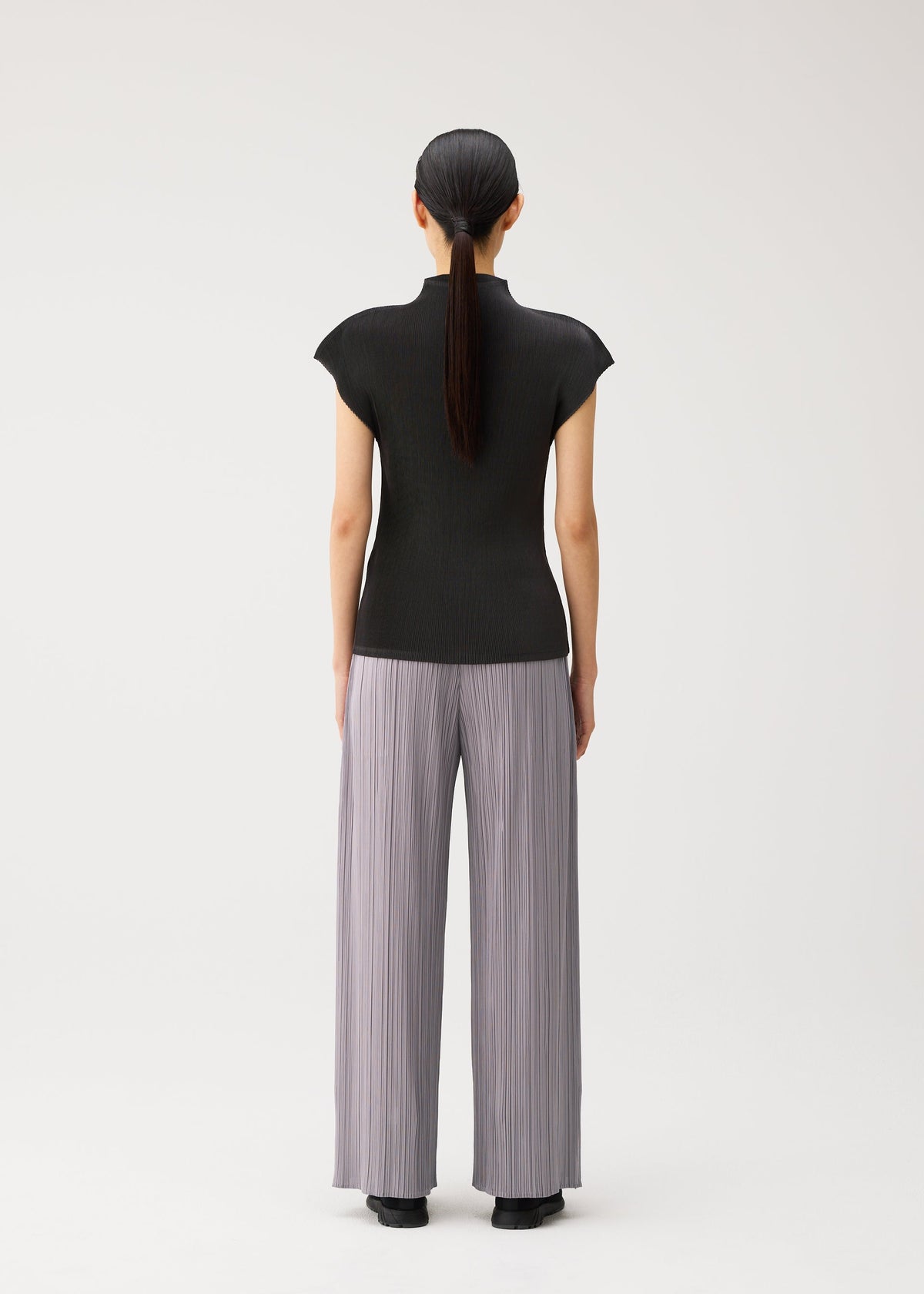 A model wears the PLEATS PLEASE ISSEY MIYAKE MIST AUGUST mist-august-cap-sleeved-high-neck-top-greyish-green.