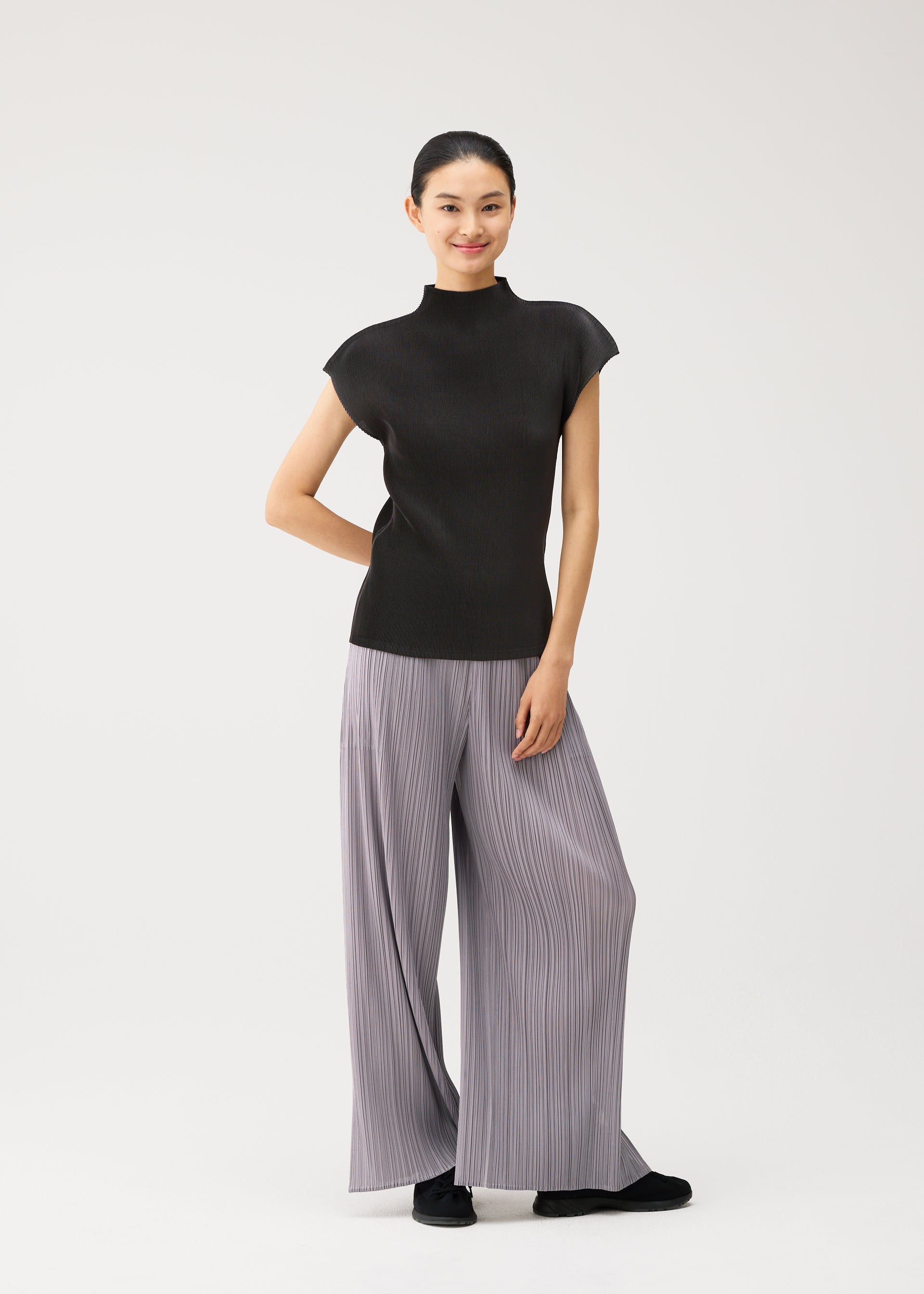 A model wears the PLEATS PLEASE ISSEY MIYAKE MIST AUGUST mist-august-cap-sleeved-high-neck-top-greyish-green.