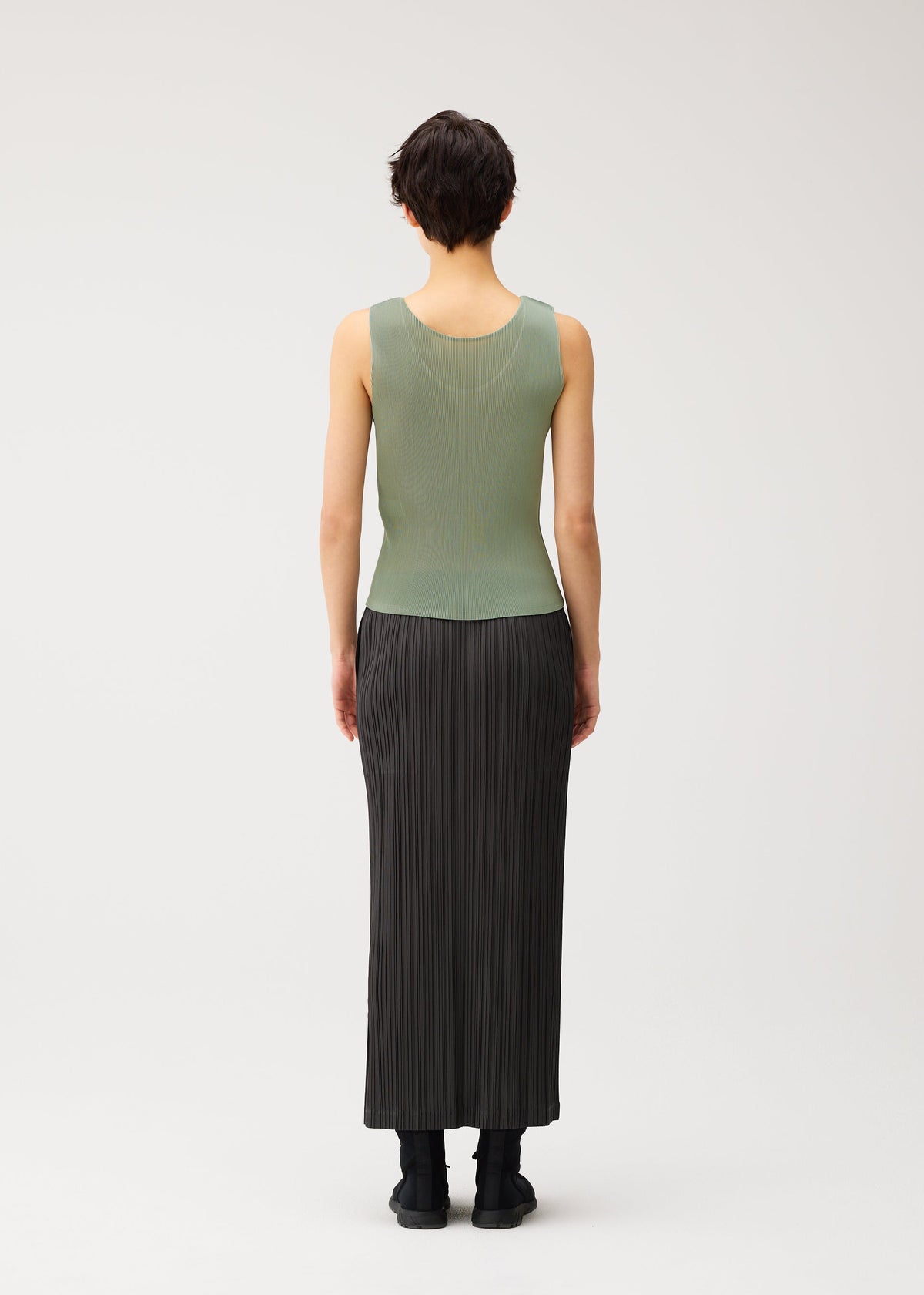 A model wears the PLEATS PLEASE ISSEY MIYAKE MIST SEPTEMBER mist-september-top-navy.