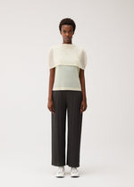 A model wears the PLEATS PLEASE ISSEY MIYAKE TATAMI AUGUST tatami-august-top-off-white.
