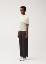 A model wears the PLEATS PLEASE ISSEY MIYAKE TATAMI AUGUST tatami-august-top-off-white.