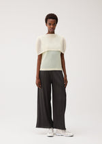 A model wears the PLEATS PLEASE ISSEY MIYAKE TATAMI AUGUST tatami-august-top-off-white.