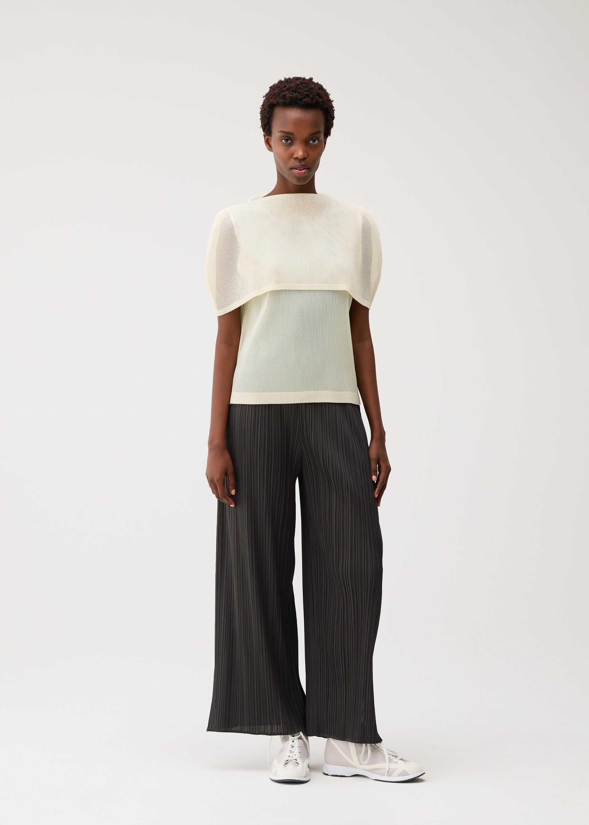 A model wears the PLEATS PLEASE ISSEY MIYAKE TATAMI AUGUST tatami-august-top-off-white.