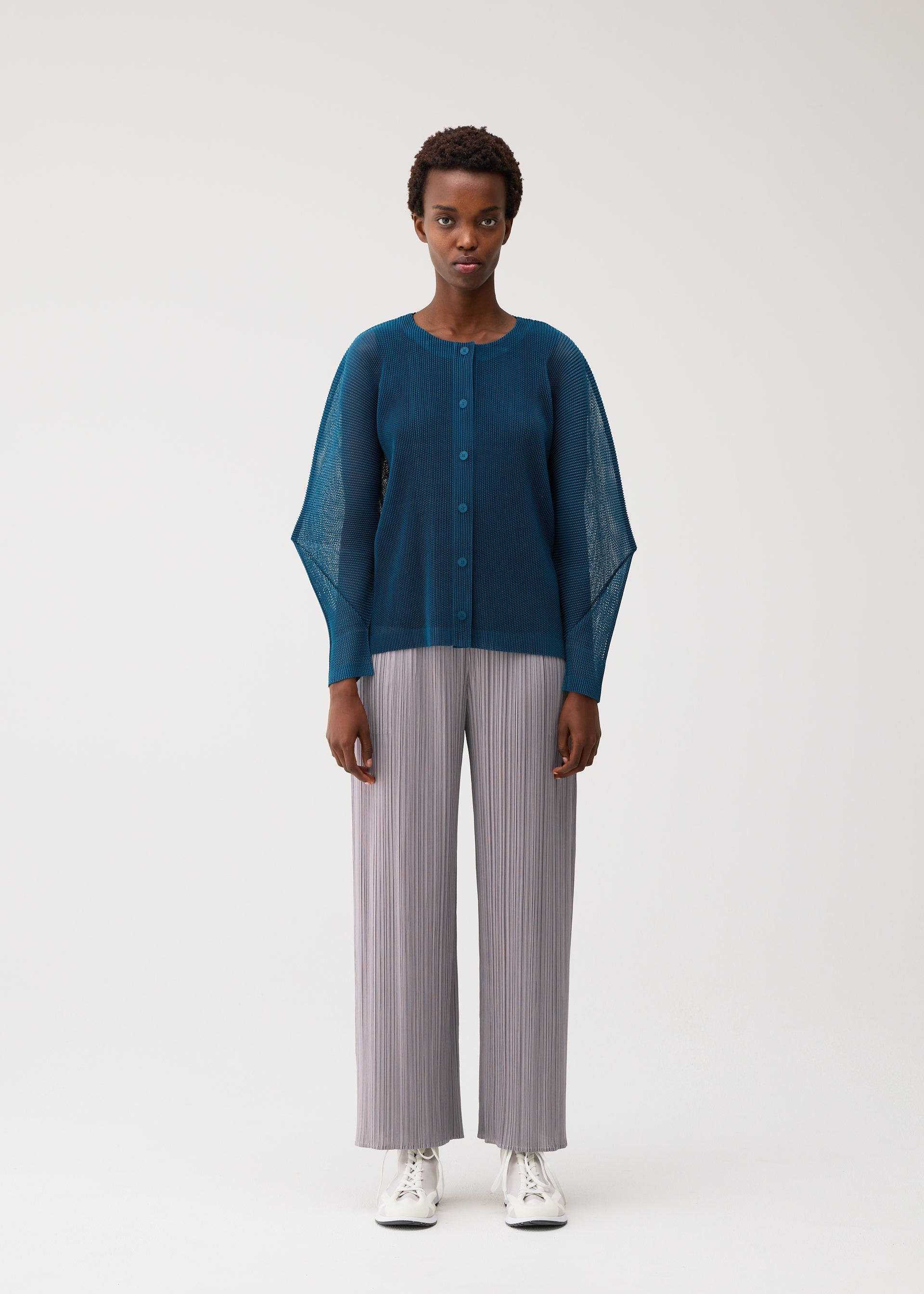 A model wears the PLEATS PLEASE ISSEY MIYAKE TATAMI AUGUST tatami-august-cardigan-marine-blue.