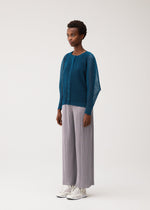 A model wears the PLEATS PLEASE ISSEY MIYAKE TATAMI AUGUST tatami-august-cardigan-off-white.