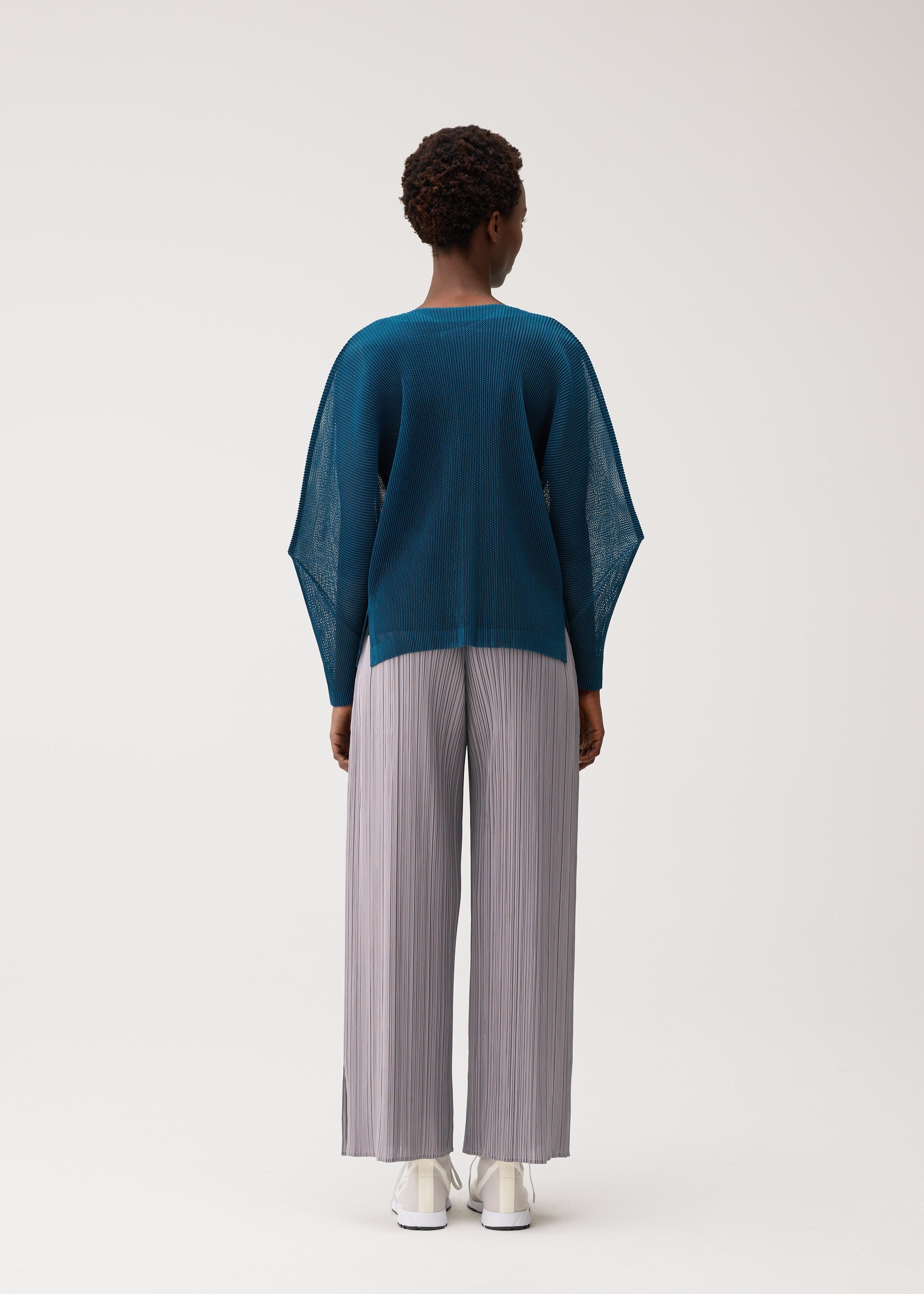 A model wears the PLEATS PLEASE ISSEY MIYAKE TATAMI AUGUST tatami-august-cardigan-off-white.