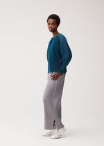 A model wears the PLEATS PLEASE ISSEY MIYAKE TATAMI AUGUST tatami-august-cardigan-off-white.