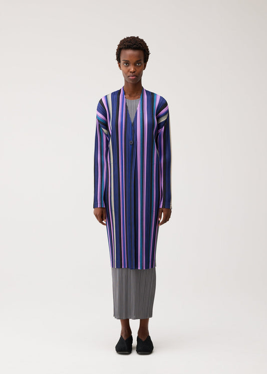 A model wears the PLEATS PLEASE ISSEY MIYAKE TAPE TAPE tape-tape-coat-orange.