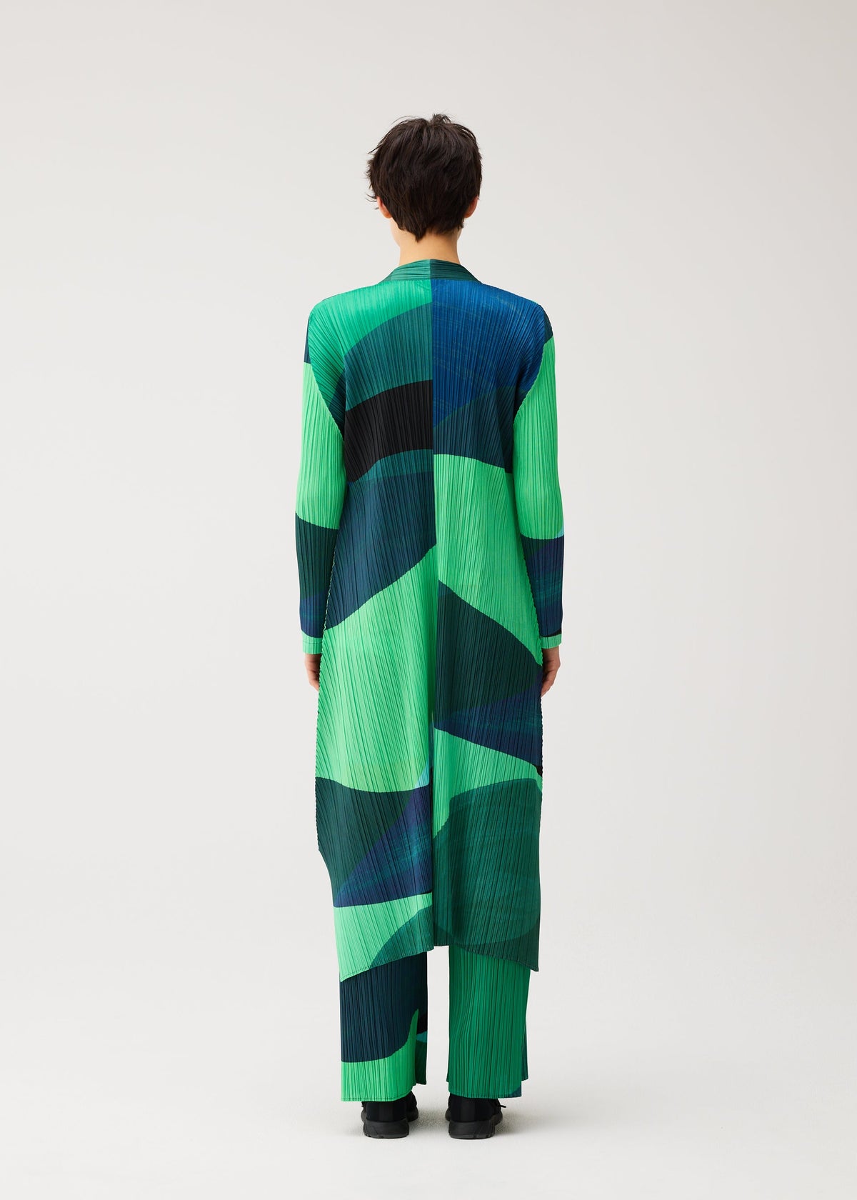 A model wears the PLEATS PLEASE ISSEY MIYAKE ORBIT orbit-coat-green.