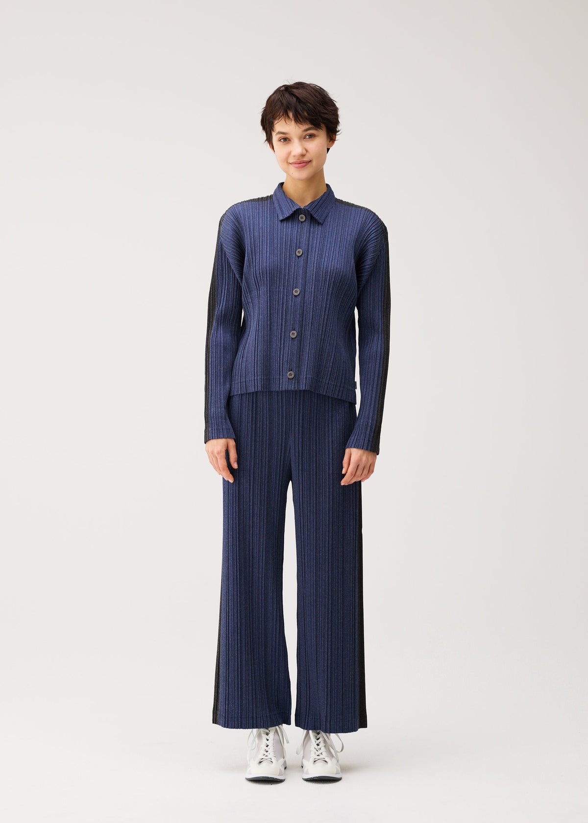 A model wears the PLEATS PLEASE ISSEY MIYAKE COTTON DENIM cotton-denim-jacket-dark-green.