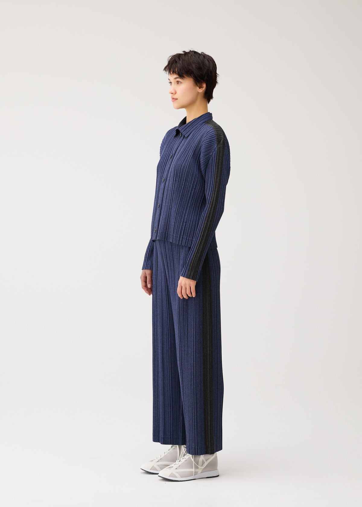 A model wears the PLEATS PLEASE ISSEY MIYAKE COTTON DENIM cotton-denim-jacket-navy-blue.