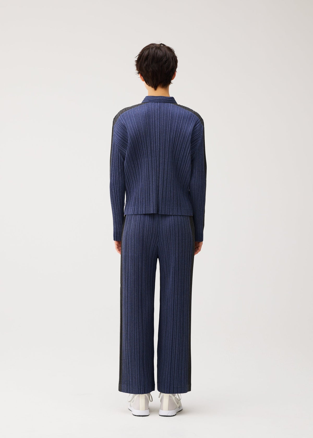 A model wears the PLEATS PLEASE ISSEY MIYAKE COTTON DENIM cotton-denim-jacket-dark-green.