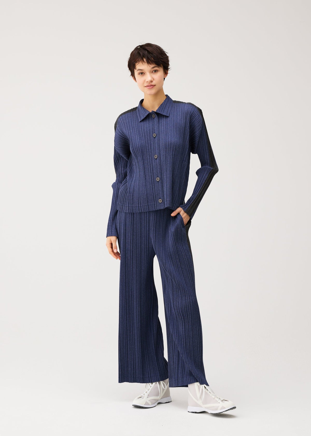 A model wears the PLEATS PLEASE ISSEY MIYAKE COTTON DENIM cotton-denim-jacket-dark-green.