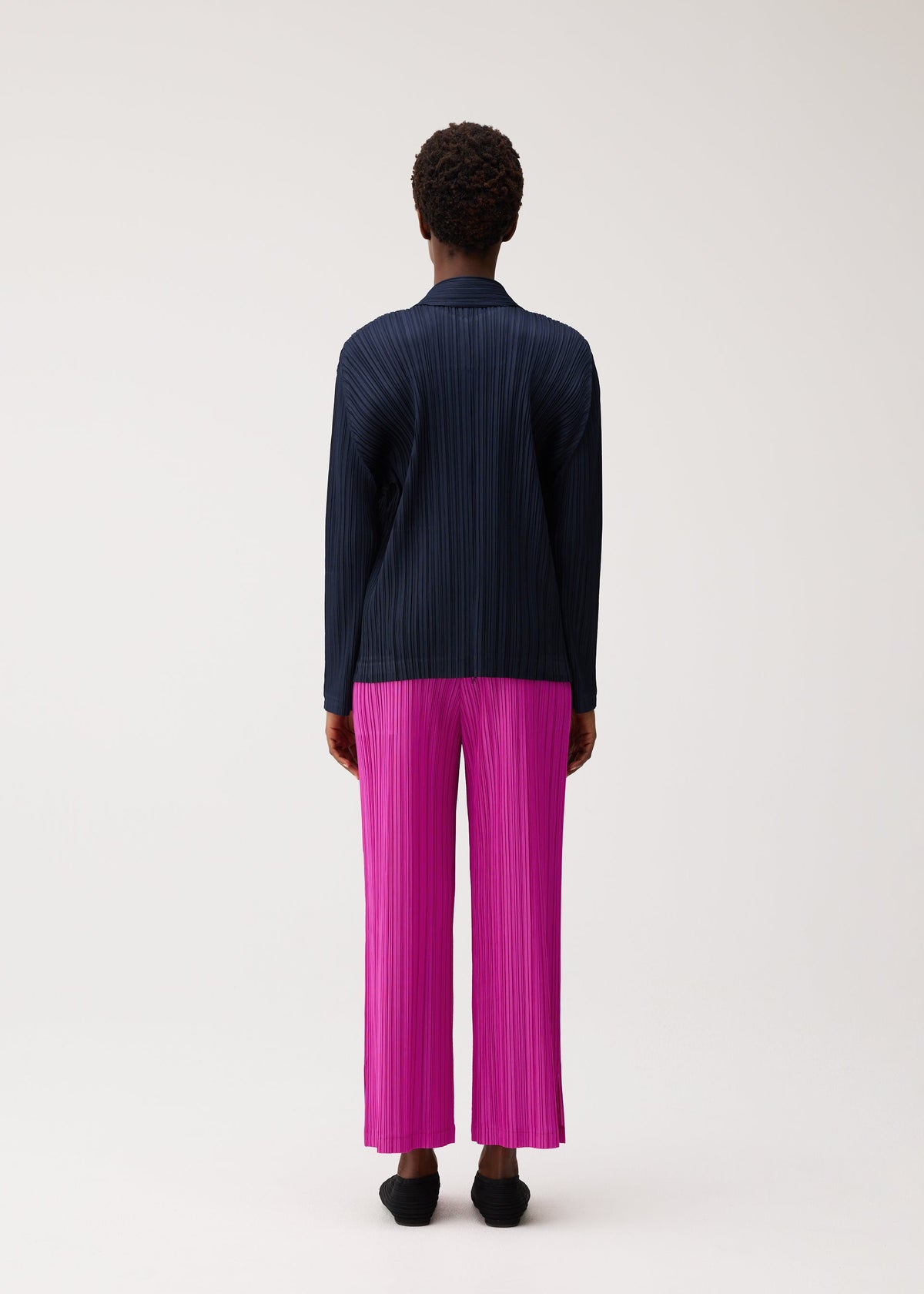 A model wears the PLEATS PLEASE ISSEY MIYAKE PLEATS JACKET pleats-jacket-jacket-navy.