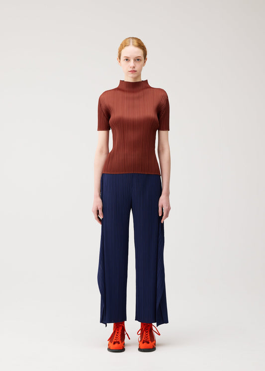 A model wears the PLEATS PLEASE ISSEY MIYAKE MONTHLY COLORS : SEPTEMBER monthly-colors-september-trousers-orange.