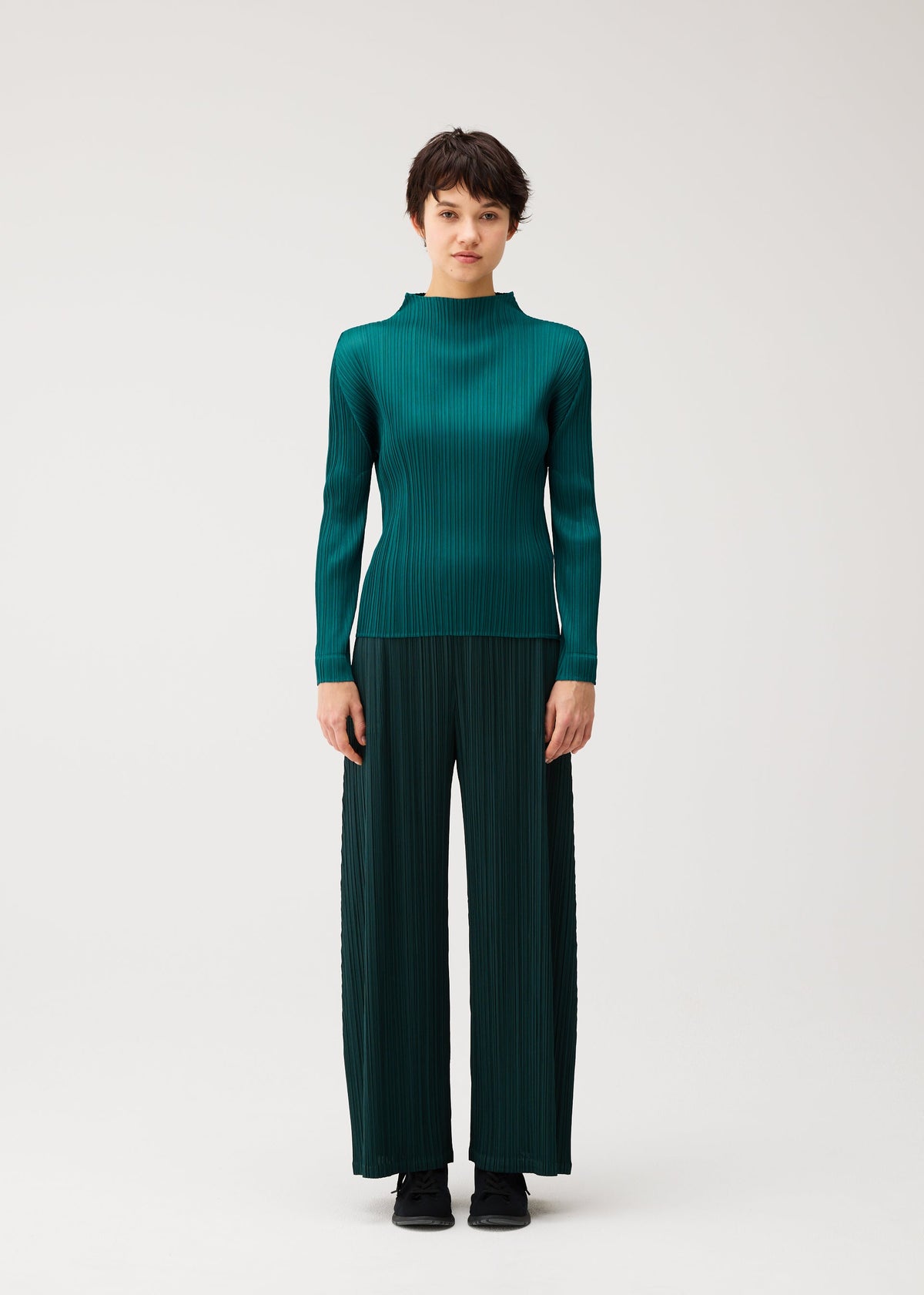A model wears the PLEATS PLEASE ISSEY MIYAKE MONTHLY COLORS : OCTOBER monthly-colors-october-wide-leg-trousers-blue-green.