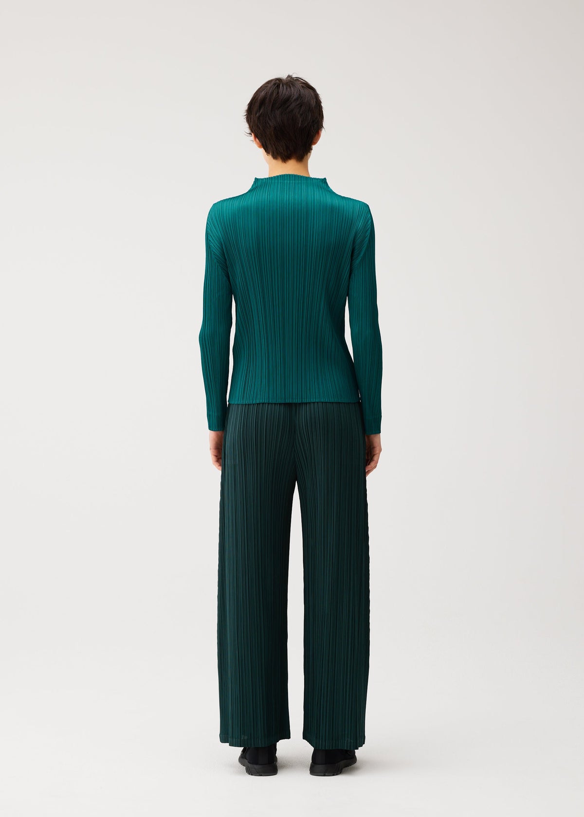 A model wears the PLEATS PLEASE ISSEY MIYAKE MONTHLY COLORS : OCTOBER monthly-colors-october-wide-leg-trousers-yellow-ochre.