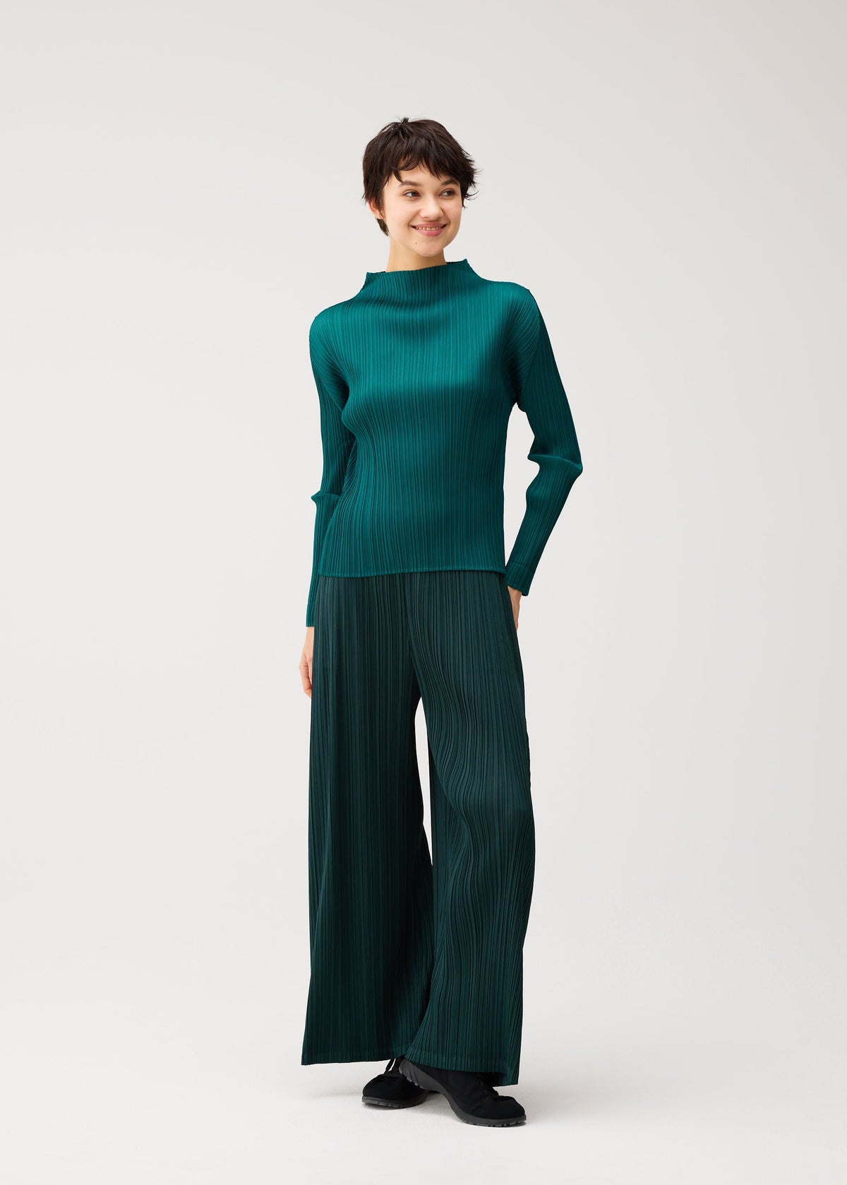 A model wears the PLEATS PLEASE ISSEY MIYAKE MONTHLY COLORS : OCTOBER monthly-colors-october-wide-leg-trousers-ash-beige.