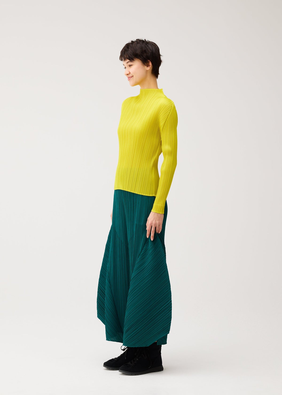A model wears the PLEATS PLEASE ISSEY MIYAKE MONTHLY COLORS : OCTOBER monthly-colors-october-flared-trousers-ash-beige.
