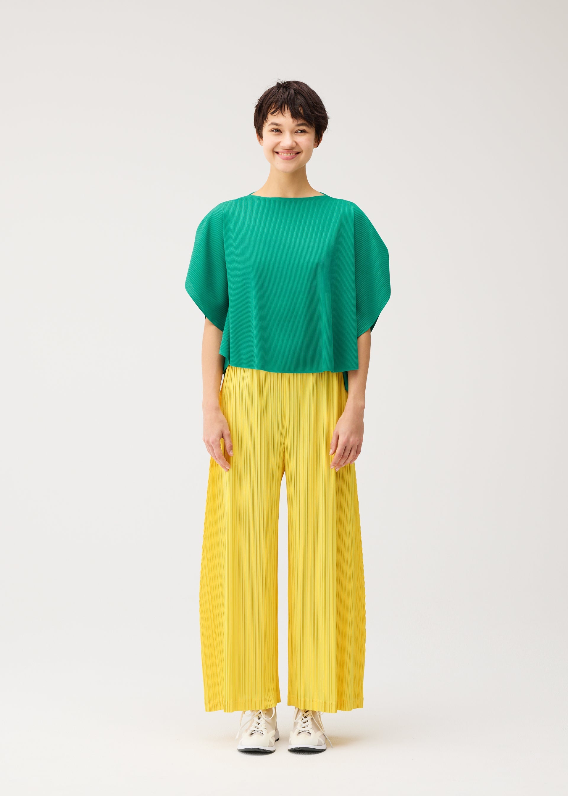 A model wears the PLEATS PLEASE ISSEY MIYAKE THICKER BOTTOMS 1 trousers.