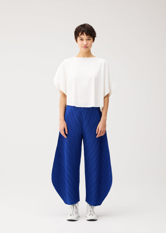 A model wears the PLEATS PLEASE ISSEY MIYAKE THICKER BOTTOMS 1 trousers.