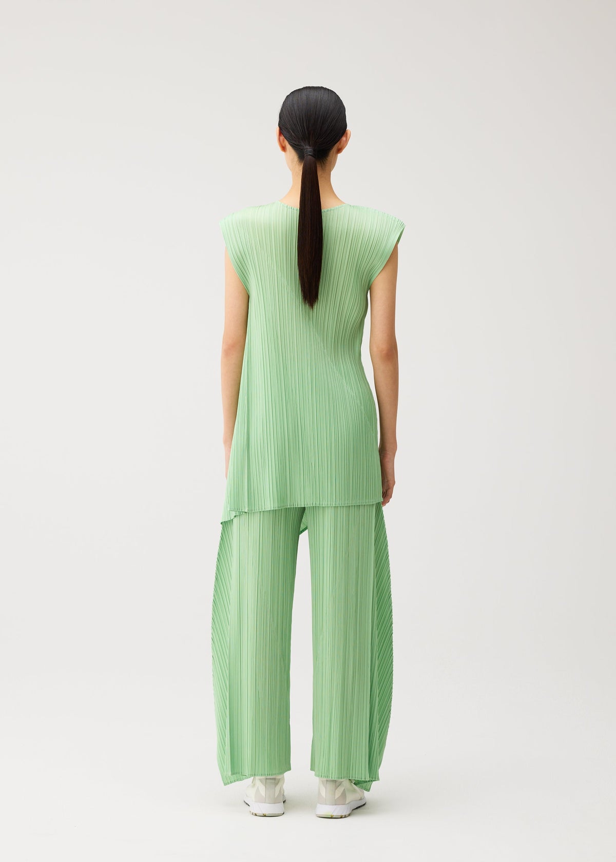 A model wears the PLEATS PLEASE ISSEY MIYAKE FOLD fold-trousers-baby-blue.