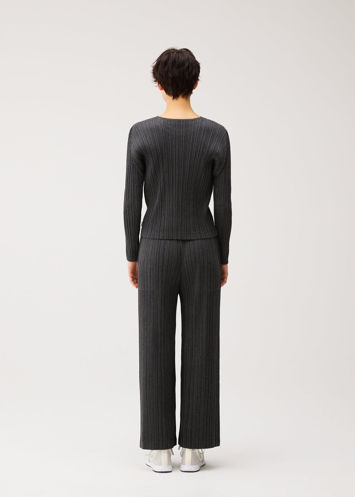 A model wears the PLEATS PLEASE ISSEY MIYAKE COTTON DENIM BLACK cotton-denim-black-trousers-black.