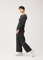 A model wears the PLEATS PLEASE ISSEY MIYAKE COTTON DENIM BLACK cotton-denim-black-trousers-black.