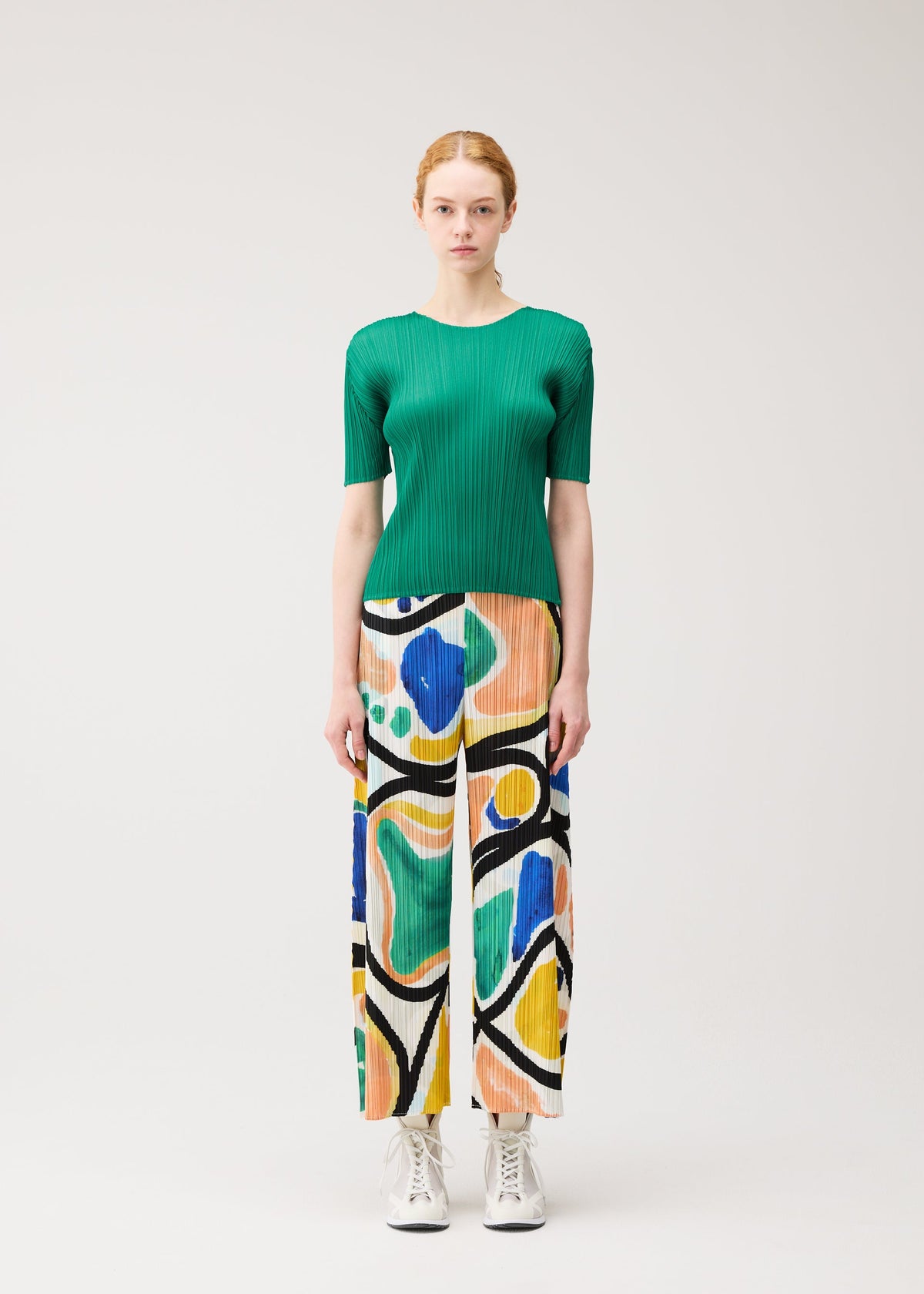A model wears the PLEATS PLEASE ISSEY MIYAKE ROLL trousers.