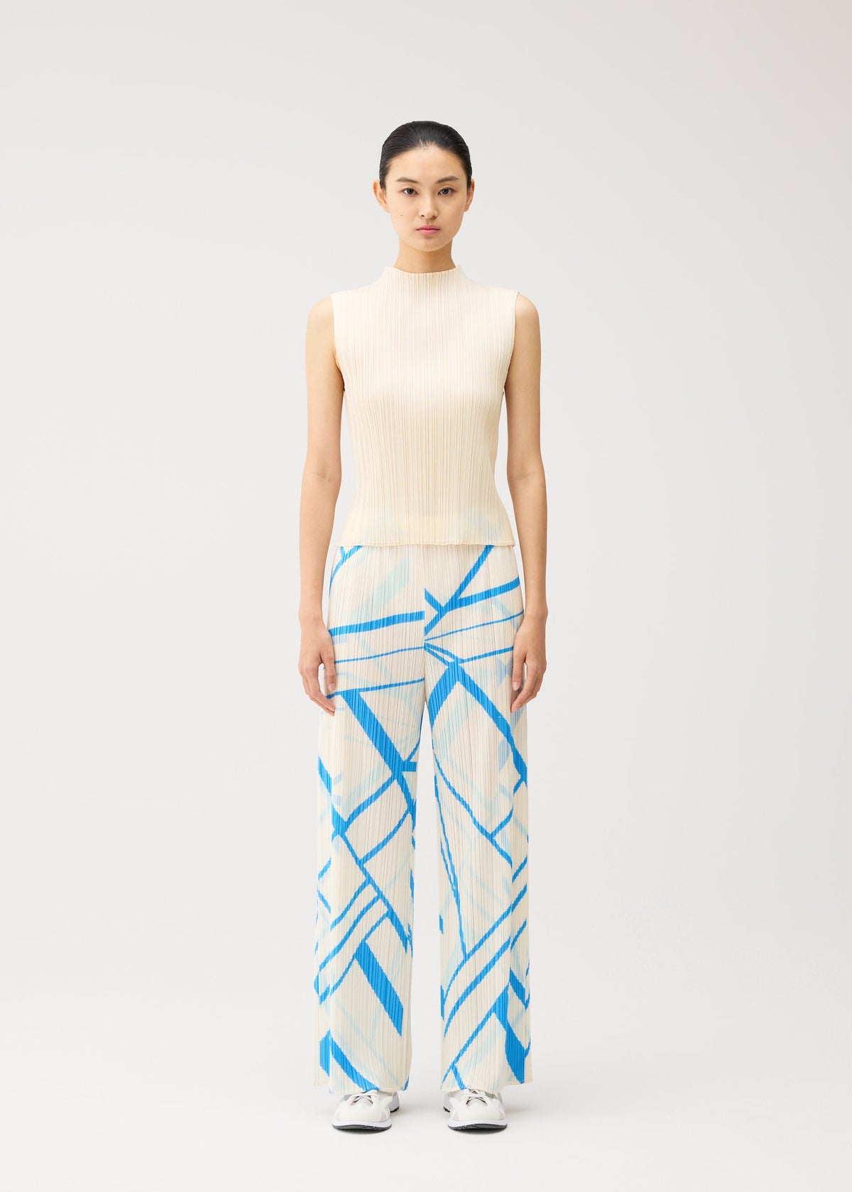 A model wears the PLEATS PLEASE ISSEY MIYAKE FOLD LINE fold-line-trousers-charcoal.