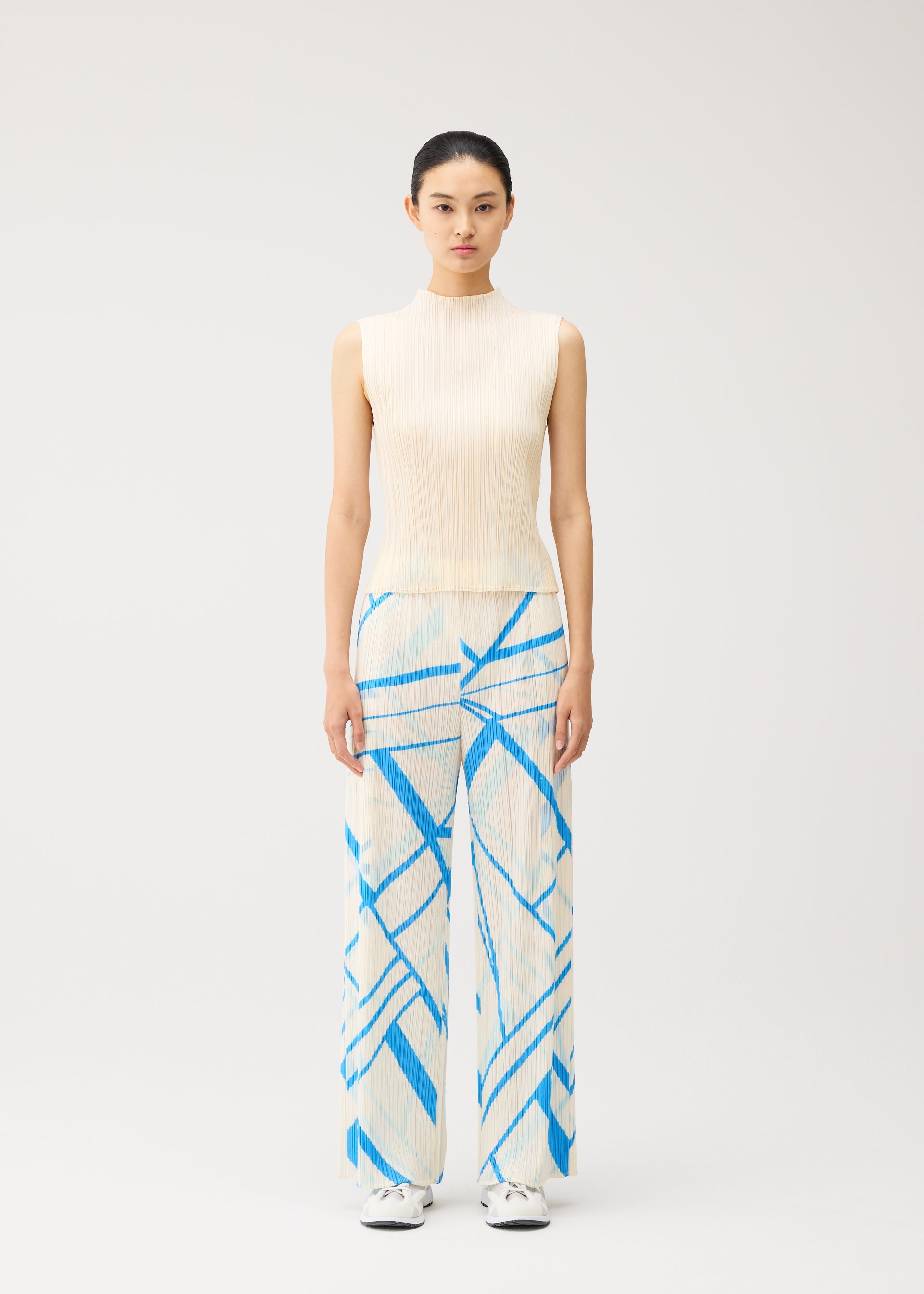 A model wears the PLEATS PLEASE ISSEY MIYAKE FOLD LINE fold-line-trousers-off-white.