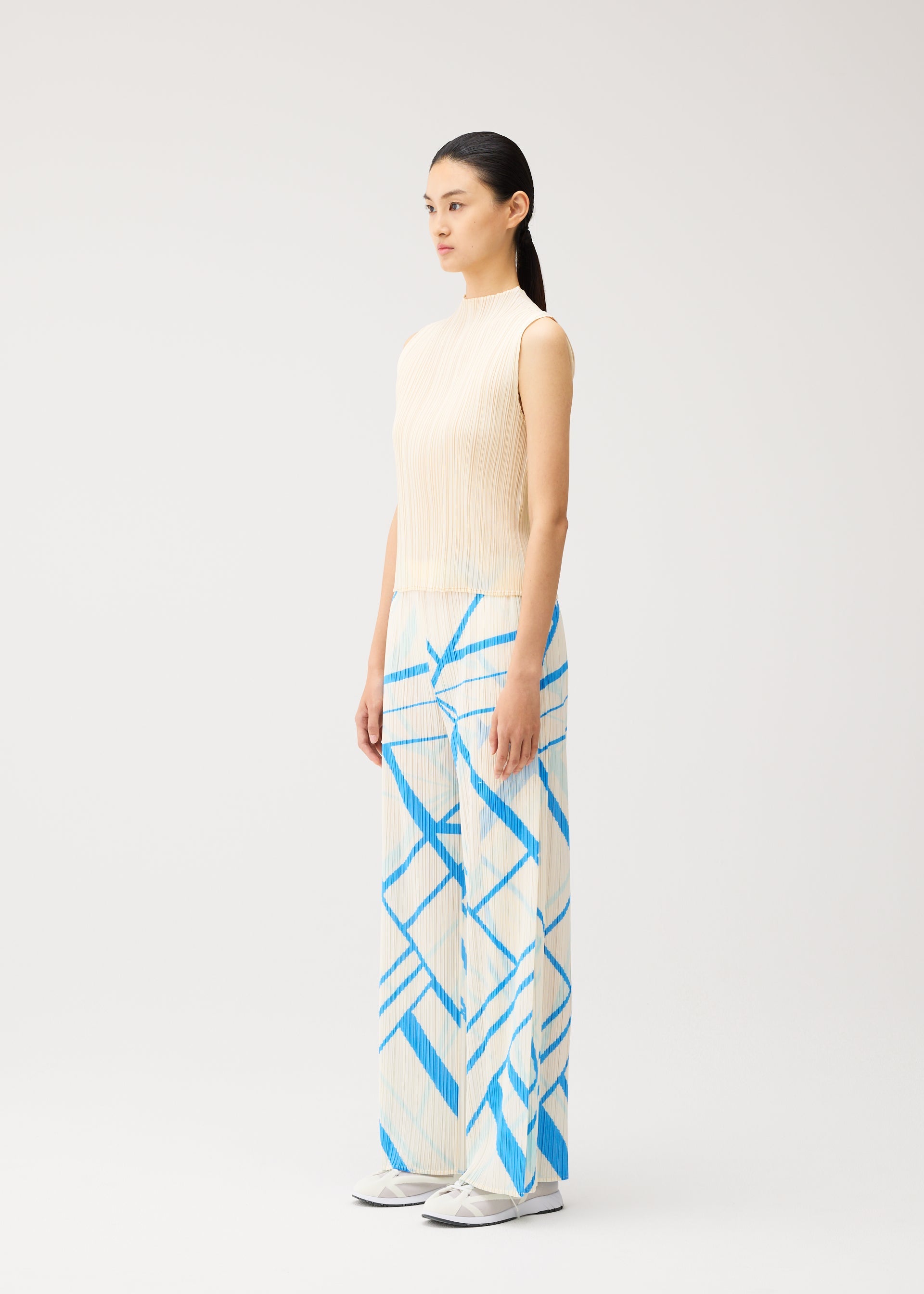 A model wears the PLEATS PLEASE ISSEY MIYAKE FOLD LINE fold-line-trousers-off-white.