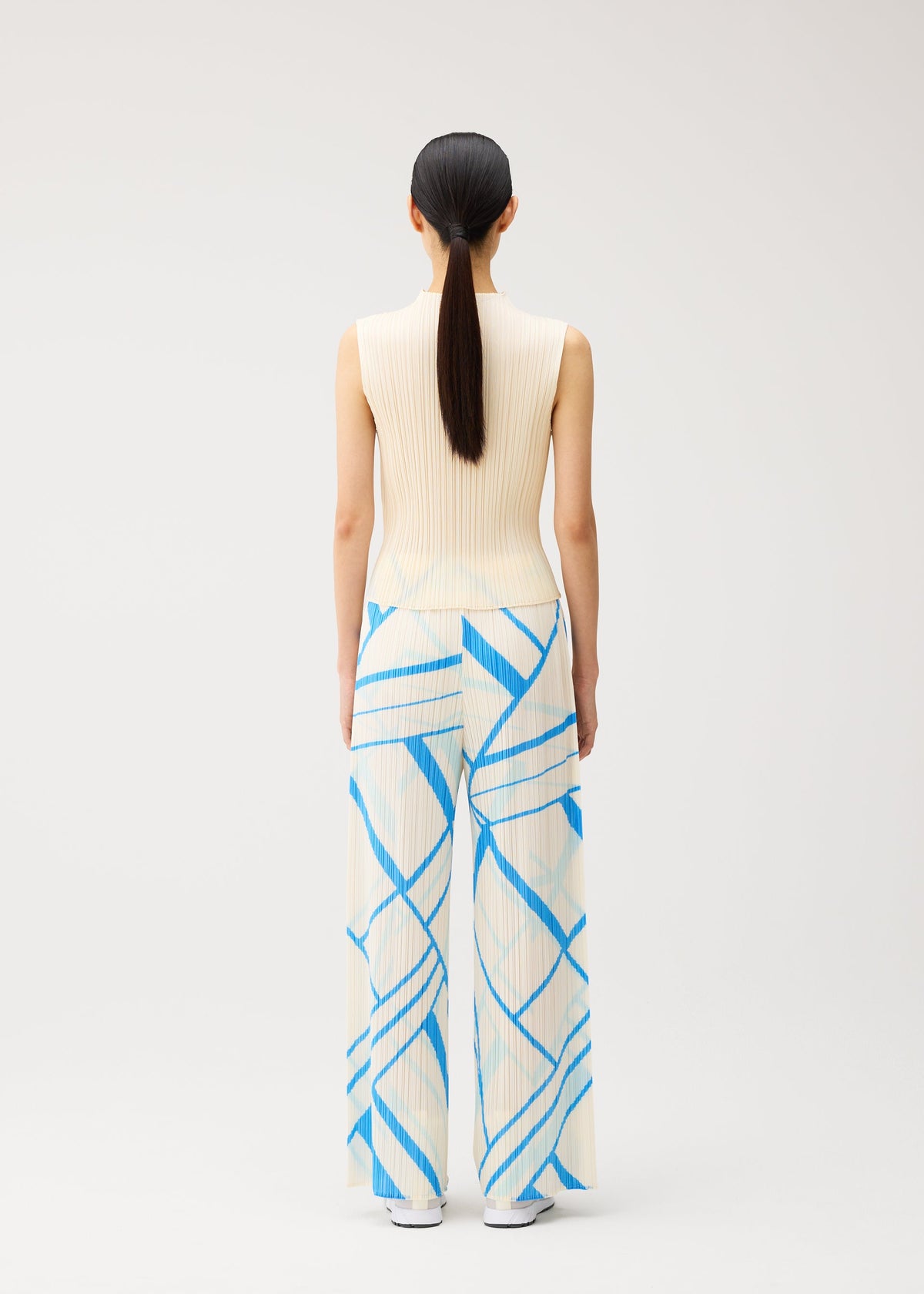 A model wears the PLEATS PLEASE ISSEY MIYAKE FOLD LINE fold-line-trousers-off-white.