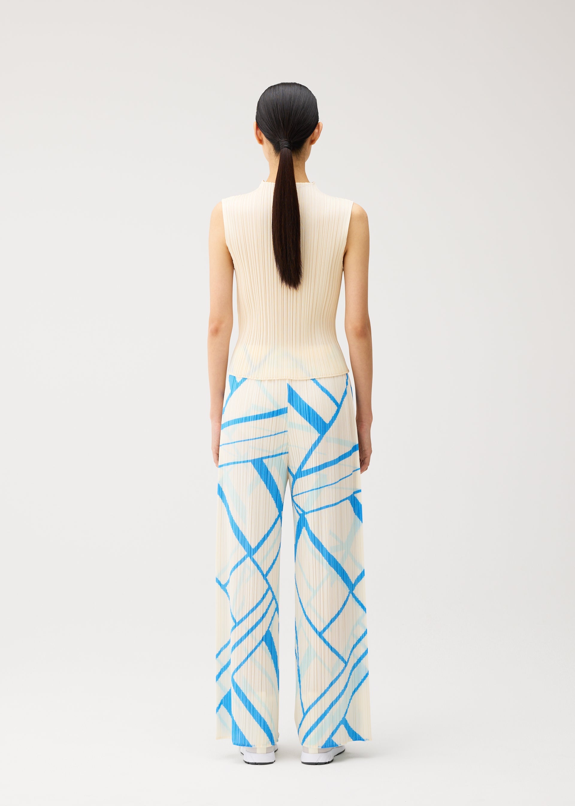 A model wears the PLEATS PLEASE ISSEY MIYAKE FOLD LINE fold-line-trousers-off-white.