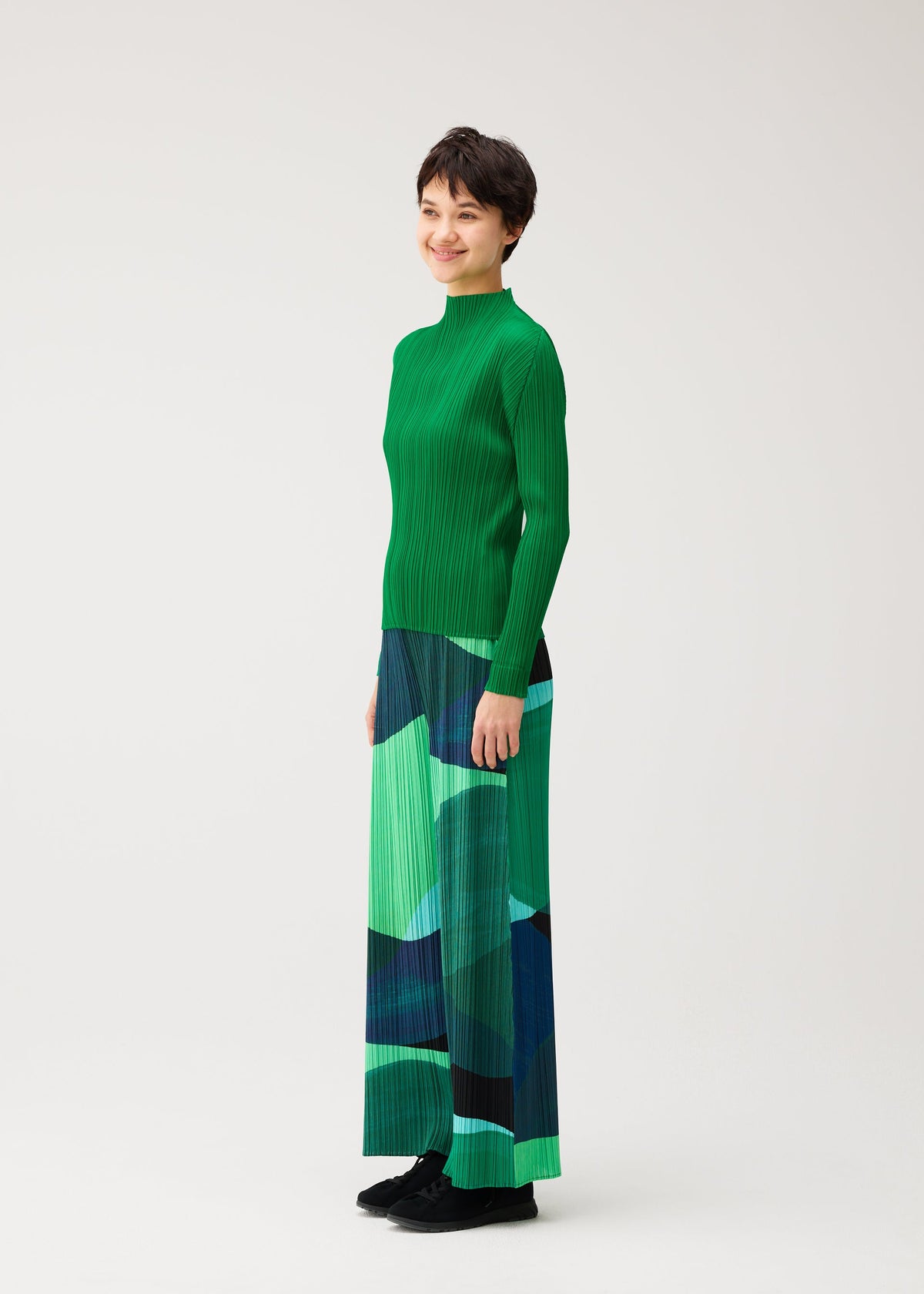 A model wears the PLEATS PLEASE ISSEY MIYAKE ORBIT orbit-trousers-yellow.