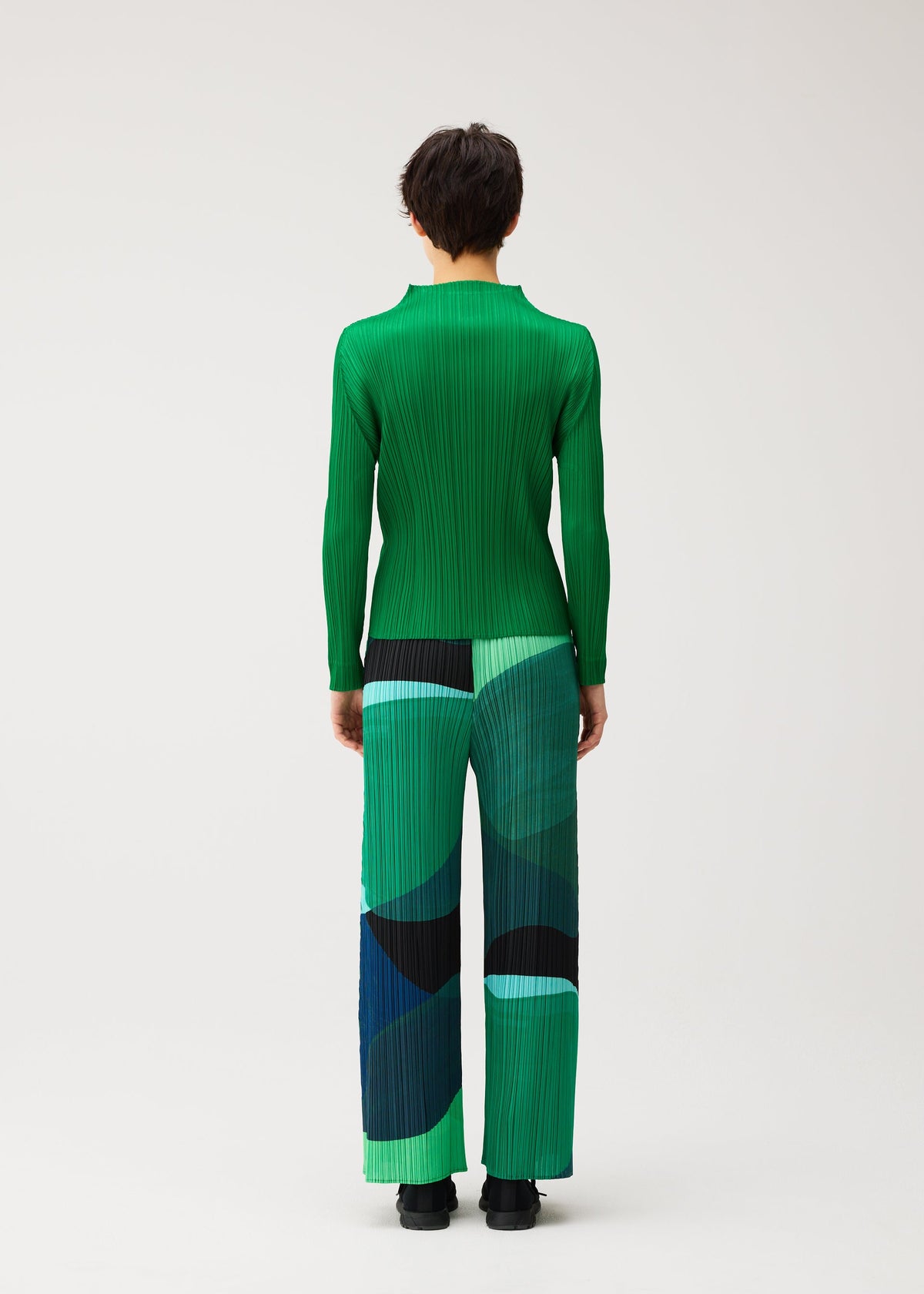 A model wears the PLEATS PLEASE ISSEY MIYAKE ORBIT orbit-trousers-green.