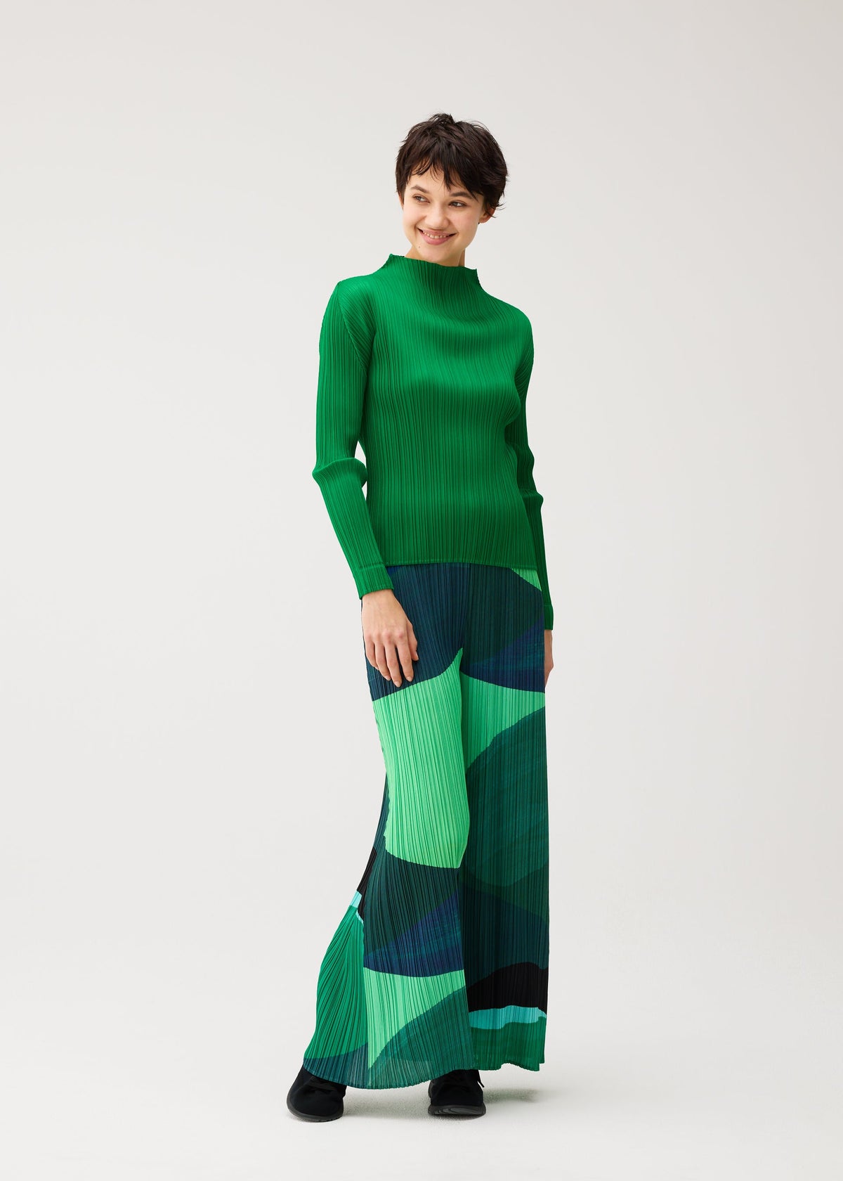 A model wears the PLEATS PLEASE ISSEY MIYAKE ORBIT orbit-trousers-yellow.