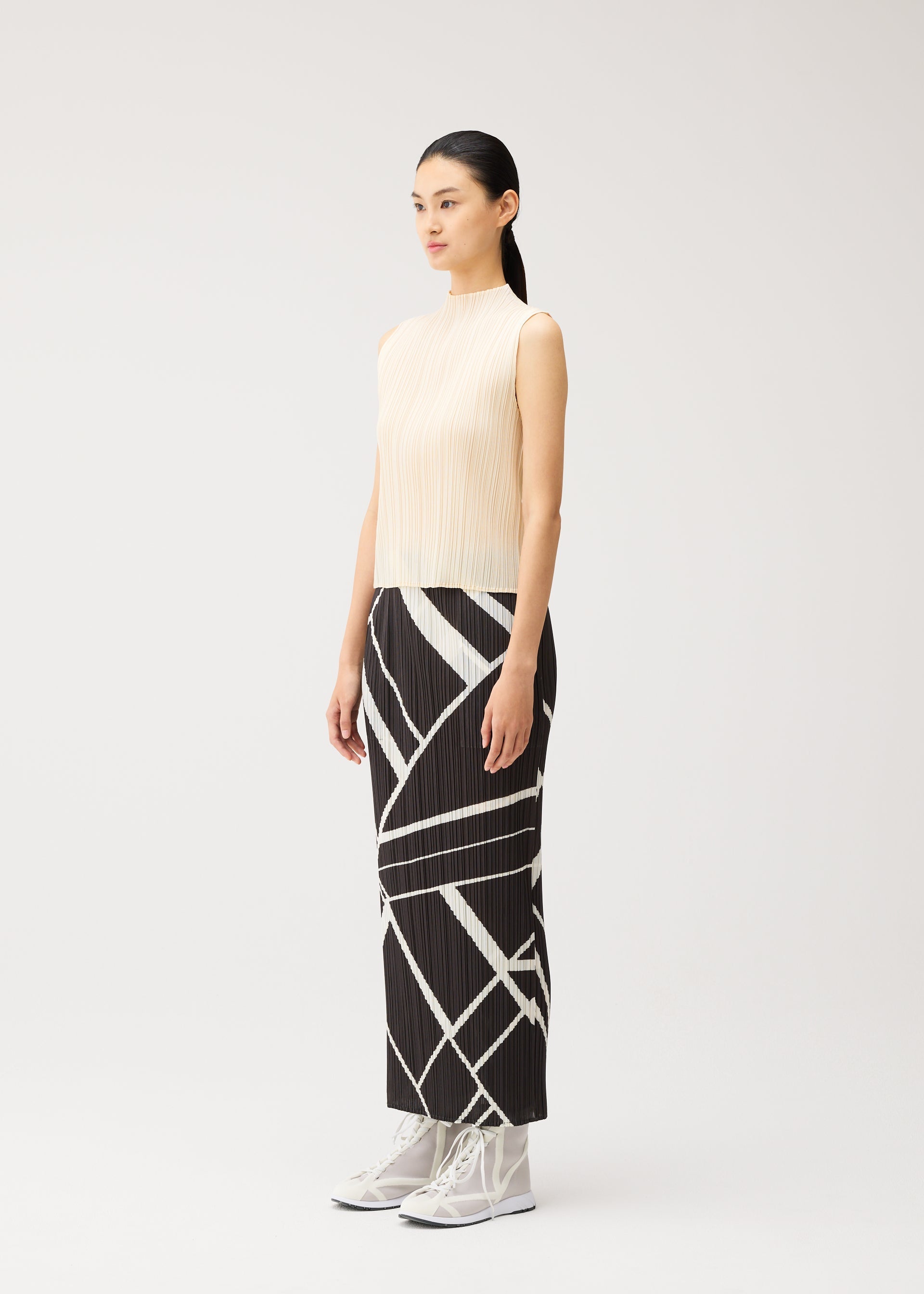 A model wears the PLEATS PLEASE ISSEY MIYAKE FOLD LINE fold-line-skirt-charcoal.